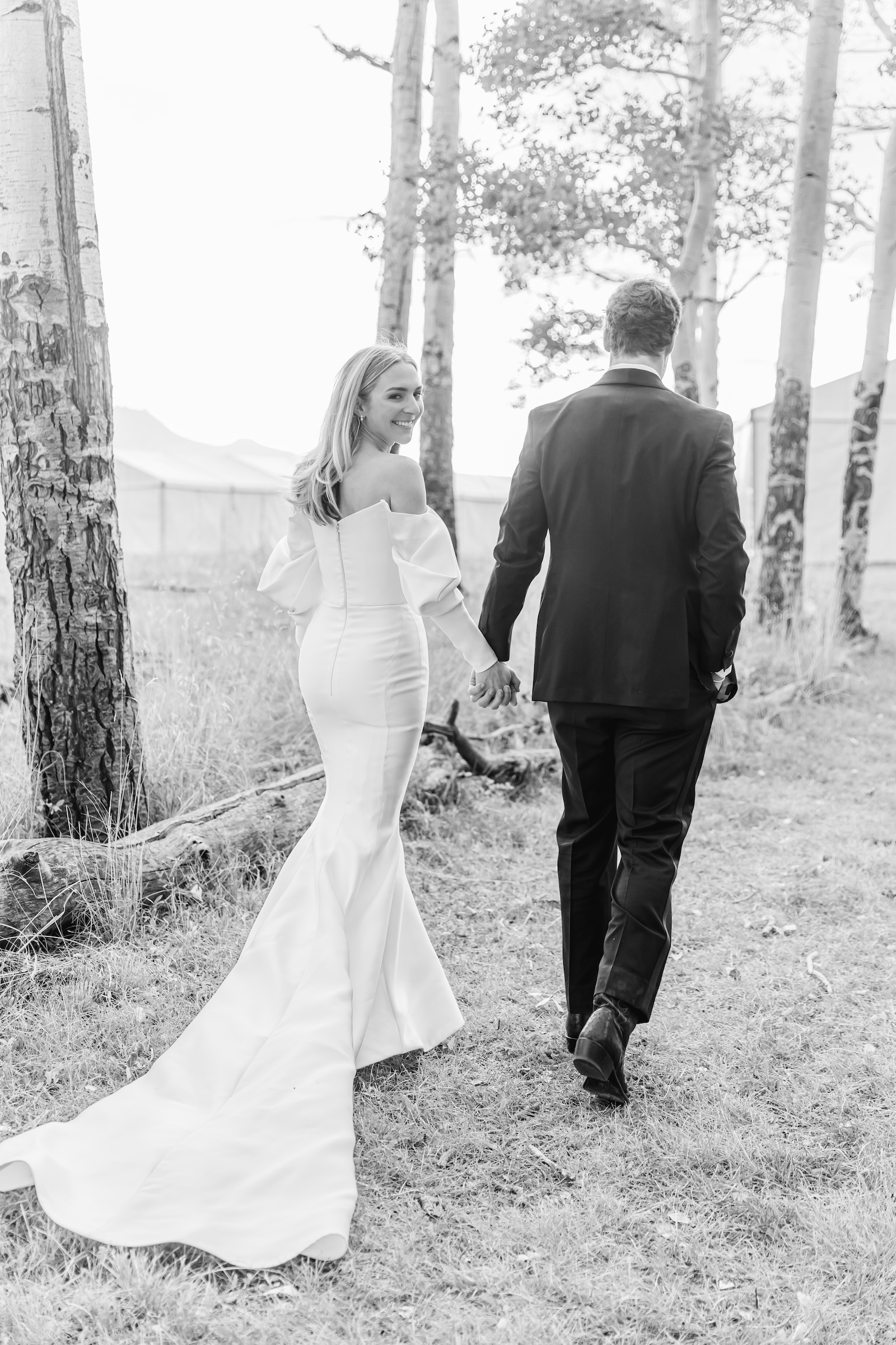 Black and white image of bride and group walking in telluride mountains